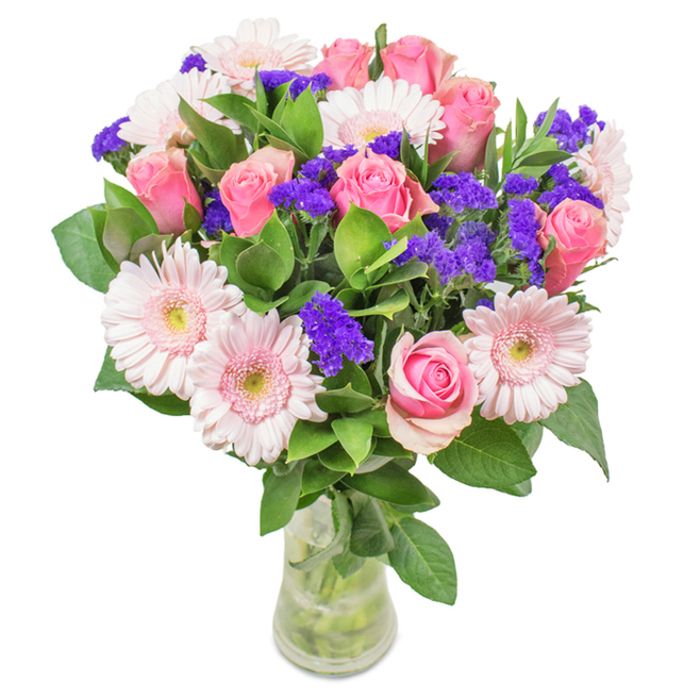 Vibrant and meticulously composed, this Nunhead bouquet features a breathtaking mix of roughly 7 to 9 pink roses at various stages of bloom-some tightly coiled, others just beginning to open in their classic spiral. These form the focal point, surrounded by 5 to 7 pale pink gerbera daisies, whose large, rounded faces and light-centred petals create a luminous display reminiscent of blossoms near Nunhead's parks. Interspersed throughout are vivid purple statice flowers, providing dramatic textural contrast and a deeper splash of colour, while plush green foliage enhances the arrangement's freshness and fullness, echoing the lush canopies of Nunhead. Displayed in a transparent glass vase with clear water and visible stems, this bouquet evokes the essence of a refined, locally gathered gift. Florist Nunhead offers this arrangement for diverse occasions-birthdays, anniversaries, Mother's Day, or adding an affectionate touch to a home-each stem chosen to convey warmth, celebration, and care in the Nunhead community.